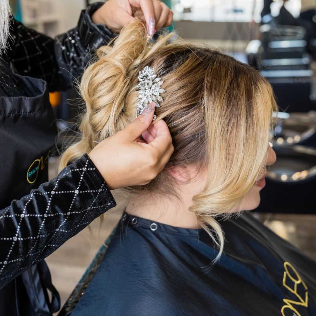 Hairstylist creating an elegant updo with a decorative hairpin.